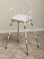 Adjustable height perching stool with arms and back, standing on a tiled floor, front view.