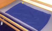 Drive slide sheet for moving and handling on a hospital bed with wooden rails and grey mattress, in use view.