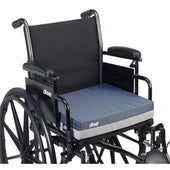 Black wheelchair with large rear wheels and a blue 4 inch gel cushion, angled side view.