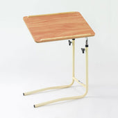Overbed table with a laminated teak top, cream angled legs, and height adjustment on white background, front view.
