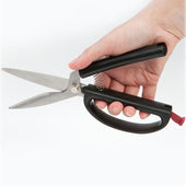 Easi-Grip Kitchen Shears with black handles and red safety lock held in hand, close-up view.