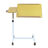 Overbed table with tilting wood top, side tray and white metal frame on wheels, shown from front angle.