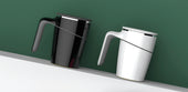 Black and white Lifemax anti-spill mugs on a white shelf with a green background, BPA free, front view.