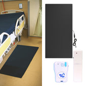Easy Link non-slip floor pressure mat with alarm transmitter and pager beside a hospital bed, white background, side view.
