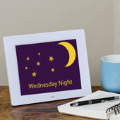 White Ravencourt Rosebud Dementia Reminder Clock showing Wednesday Night, crescent moon, stars, and a blue mug icon, front view.