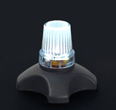 White Drive quad cane tips with ribbed tops, glowing effect on a dark background, close-up view.