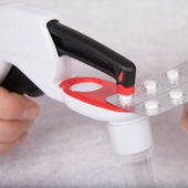 Pivotell Pill Popper pressing a tablet from a blister pack, held by hand, in use close-up.
