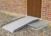 Enable Access Permaramp-Original External Ramp with Gripdeck over stone steps and gravel, leading to a door, angled view.