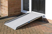 Permaramp-Adjust External Ramp with Gripdeck surface set up from brick patio to black front door, side view.