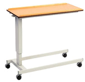Overbed table with a wooden top, white metal frame and large black wheels for moving and adjusting height, side view.