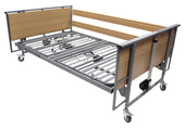 Woburn Community 1200 wide bed without mattress, metal frame, wood headboards, side rails and wheels, front angle view.