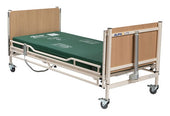 Sidhil Alphalite Electric Bed with green mattress, wooden ends, wheels, and electric backrest, side view.