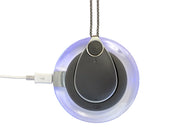 Grey Chiptech GO Pendant on a round illuminated charger with USB cable, top view.