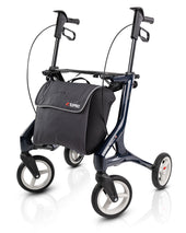 Steel blue Topro Pegasus Carbon Rollator, lightweight four-wheel walker with large front storage bag, front angle view.