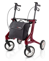 White Topro Pegasus Carbon rollator with four wheels and black front bag on a white background, front angle.