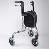 Purple three wheel rollator with black storage bag, large wheels, white background, front angle view.