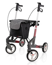 Silver Topro Troja 5G Premium rollator with hand brakes, grey storage bag, and large front wheels, front view.