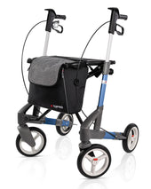 Blue Topro Troja 5G Premium rollator with four wheels, hand brakes and a black front storage bag, side view.