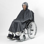 Woman in a wheelchair wearing a hooded NRS Freestyle Wheelchair Poncho, white background, front view.