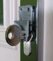 Key in a door lock fitted with the NRS Lockpal Door Key Guide for easier turning, close-up view.