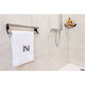 Elegance Towel Grab Rail with white towel, showerhead, and toiletries on shelf against modern bathroom wall, front view.
