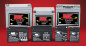 Seven Drive sealed lead-acid batteries for mobility scooters on a red background, group front view.
