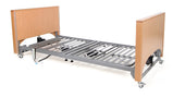Woburn Low Profiling Bed with wooden headboard and footboard, shown without mattress, side view.