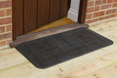 Black rubber Doorline-Neatedge ramp with grid pattern placed outside a wooden door on light wood porch, front angle.