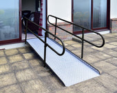 Permaramp-Adjust graphite ramp with Quickrails, self-supporting design bridging patio to door, side view.