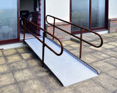 Permaramp-Adjust Ramp with Quickrails in graphite, connecting patio to sliding glass doors, side view.