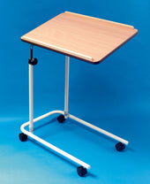 Over bed table with light wood top, white metal frame, four castors and split leg base, side angle view.