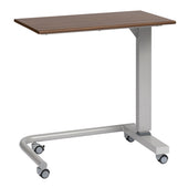 Oak overbed table with height adjustment and four wheels, shown from a side angle.