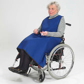 Blue Thorpe Mill Smoking Apron worn over a grey sweater by an elderly woman in a wheelchair, plain white background, front view.