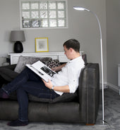 Lifemax High Vision LED Floor Lamp in black lighting a man reading on a dark grey sofa, modern living room, in use.