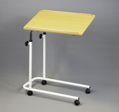 NRS overbed or overchair table in dark oak with tilting metal frame and wheels, plain grey background, angled front view.