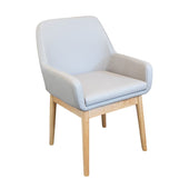 Light grey cushioned seat commode with fire retardant upholstery, wooden legs and armrests, front view.