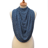 Navy clothing protector scarf on cream mannequin with white polka dots, plain background, front view.