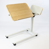 Light wood overbed table with white metal frame, adjustable height and wheels, shown from a side angle.