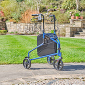Silver three wheel steel rollator with height-adjustable handles and black bag, shown on a garden stone path, front angle.