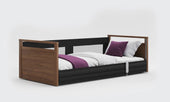 Oak Opera Beds Solo SafeSide Profiling Floor Bed with wood accents and white and purple bedding, front angle.
