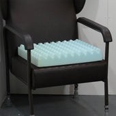 Lightweight dark chair with blue Harley Proform Standard Wheelchair Cushion, front view.