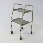 Grey NRS Home Helper trolley with two shelves, four wheels and adjustable height, side view.