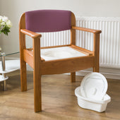 Royale Extra Wide Commode in beech and pink on a wooden floor beside a radiator, front angle.