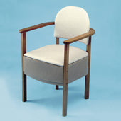 Gordon Ellis Devon Commode with upholstered seat and backrest on a light blue background, front view.