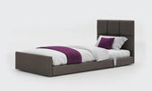 Opera Solo Comfort profiling floor bed in anthracite fabric with white bedding and purple accents, plain background, front view.