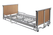 Drive Casa Elite home care bed with metal side rails, wheels, and exposed ends, shown from a side view.