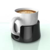 White anti-spill TableCoaster drink holder with a coffee cup and latte art, on glass surface, close-up view.