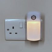 White Lifemax night light torch with round motion sensor on top, plugs into wall, soft glow, front view.