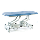 Sky blue SEERS Medical hydraulic therapy hygiene table with white frame, lockable castors, height adjustable, left side view.