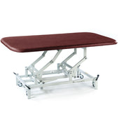 Burgundy electric therapy mat table with height adjustment, white frame and wheels, shown from side view.